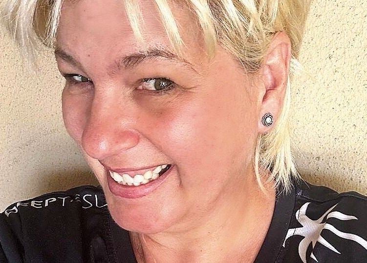 Cheerful staff member at Kahe Hands Wierdapark, Centurion, Gauteng, ZA, wearing a casual top and smiling.