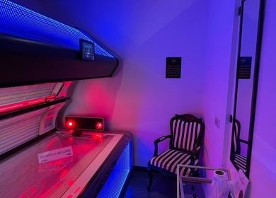 Vibrant sunroom at Confidence & Glow Aesthetics, Morley, England, GB featuring a modern tanning bed and elegant chair.