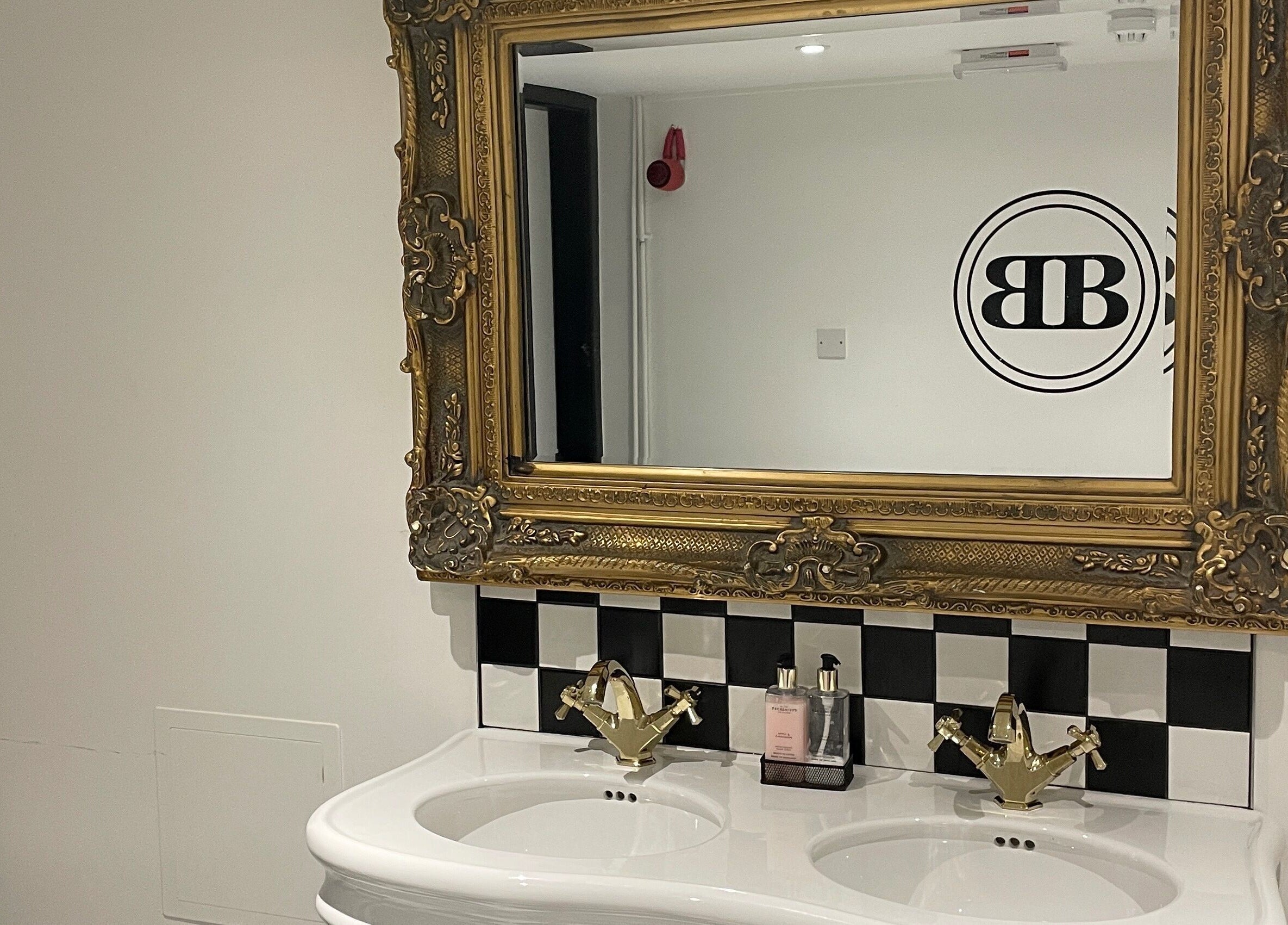 Luxurious bathroom vanity at Confidence & Glow Aesthetics, Morley, England, GB with ornate mirror and stylish sink.