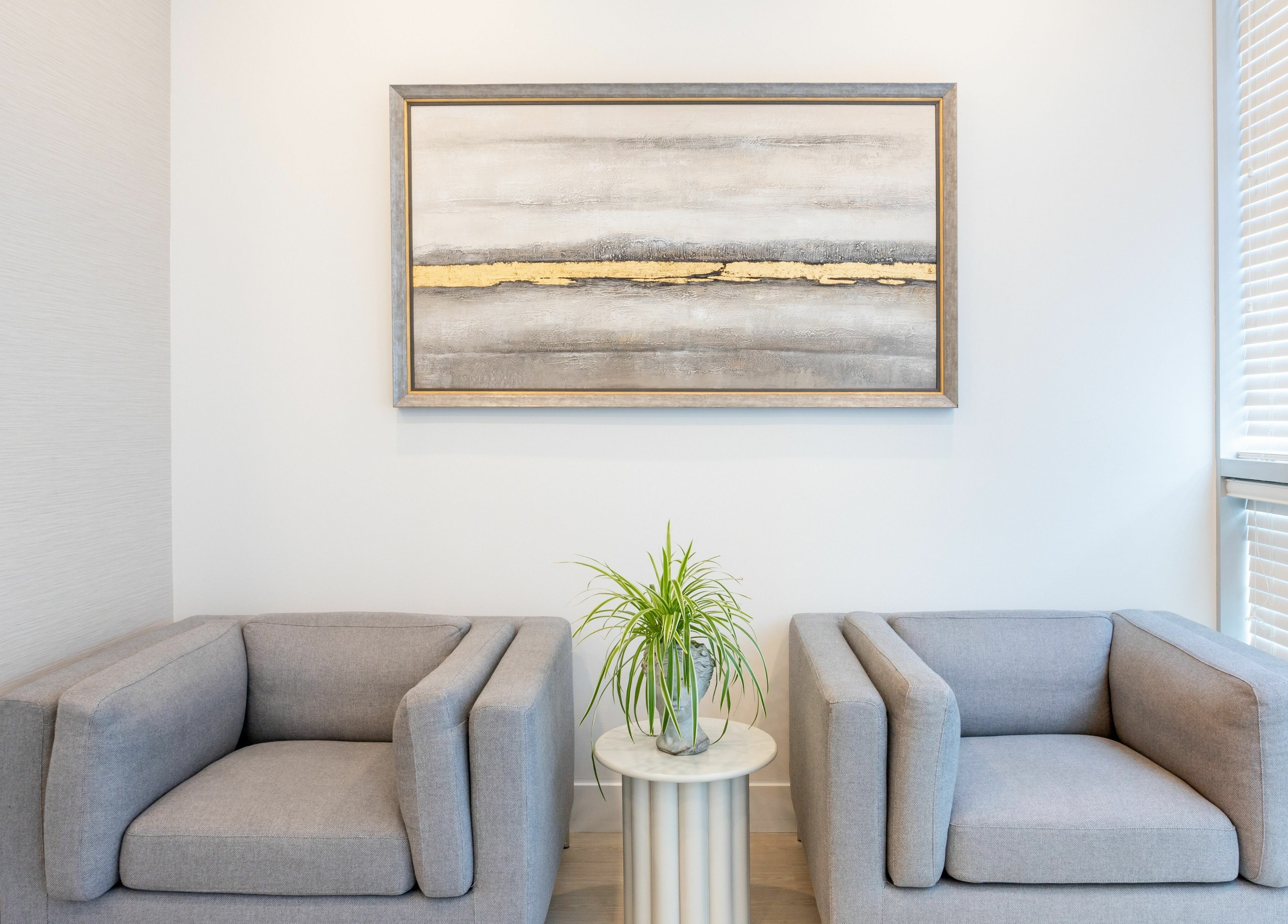 Modern lounge with grey chairs and art at MG Aesthetics, Vaughan, Ontario, CA.