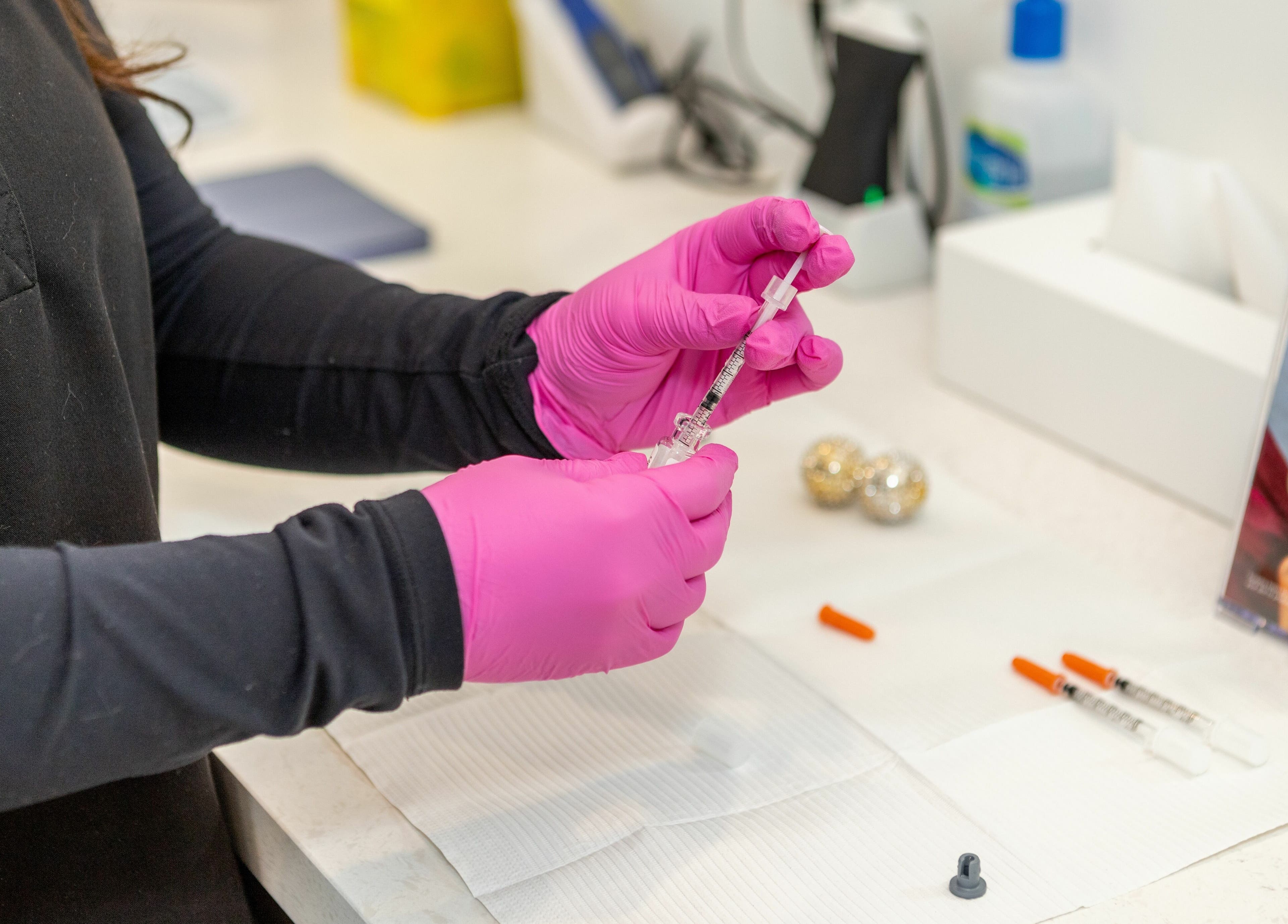 Professional preparing injection at MG Aesthetics in Vaughan, Ontario, CA with pink gloves.
