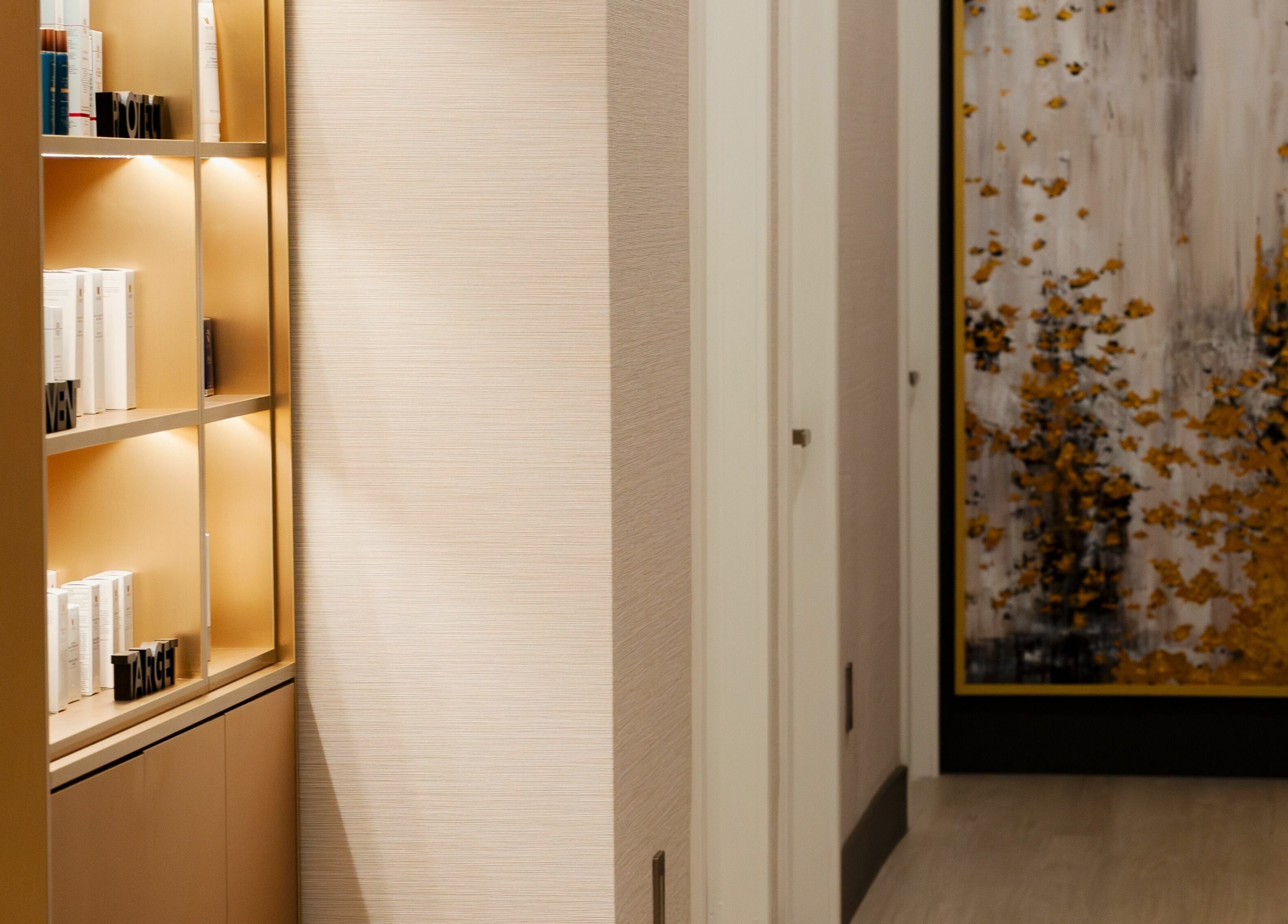 Elegant hallway and product shelf at MG Aesthetics, Vaughan, Ontario, CA, featuring a modern art piece.