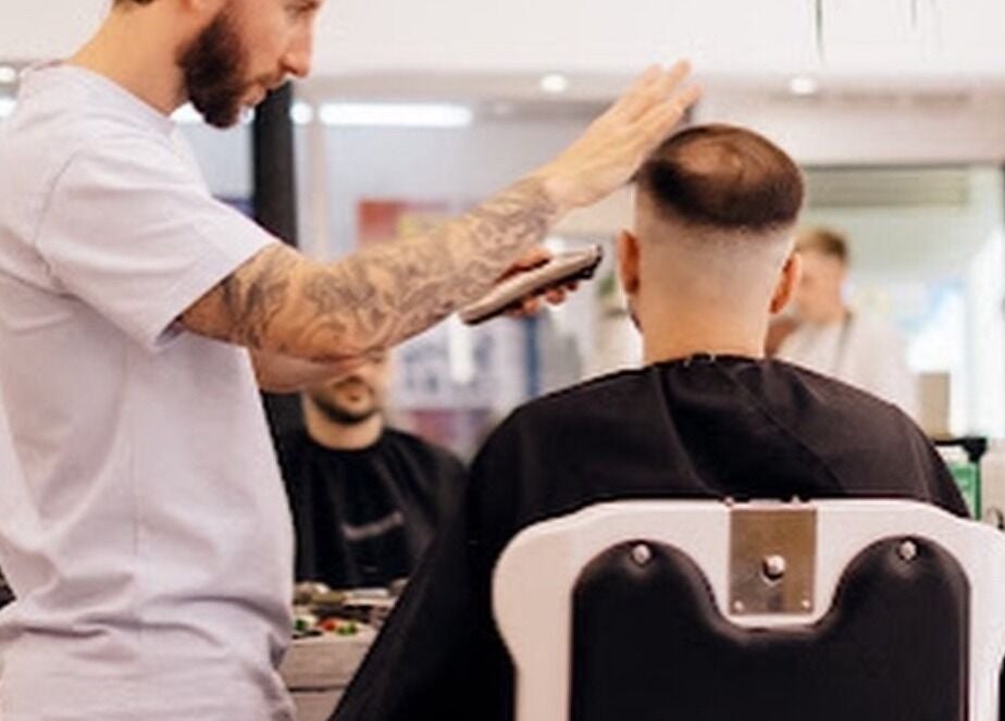 A stylist gives a haircut at The Hoi Polloi City Centre, Newcastle upon Tyne, England, GB.