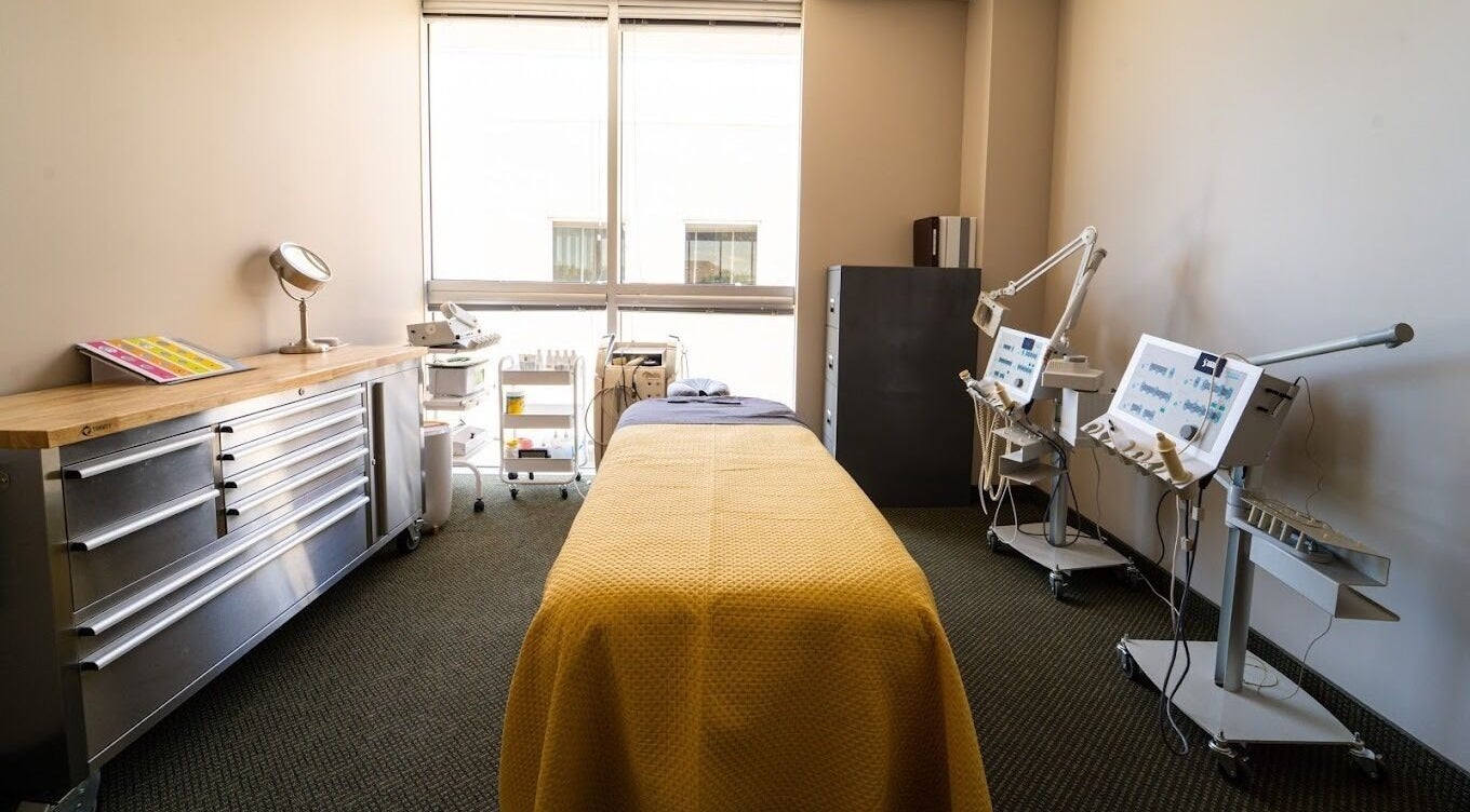 Relaxing treatment room at Stone International Wellness Center, Plano, Texas, US, featuring a massage table and equipment.