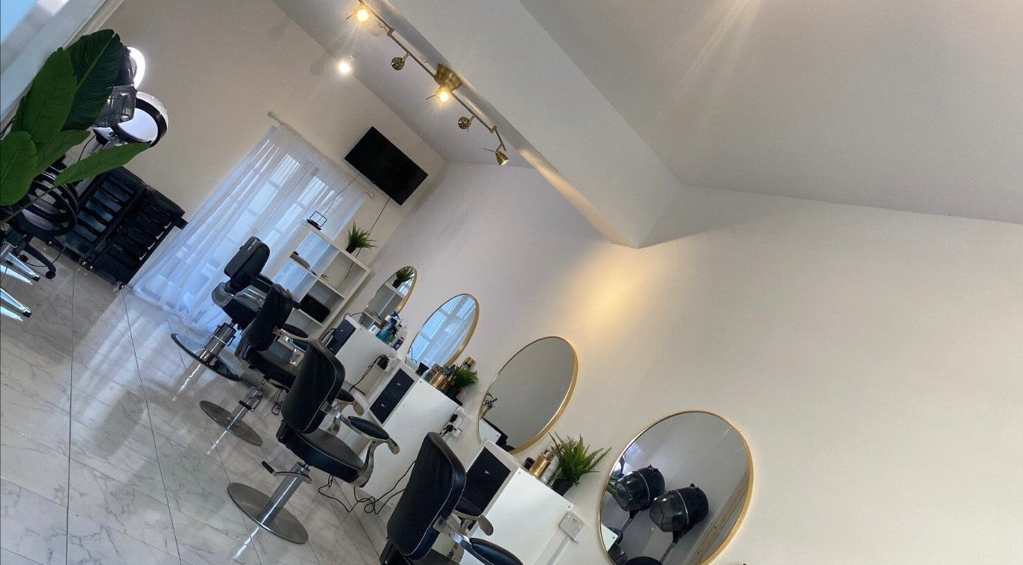 Chic interior of Innovative Salon | Hair & Beauty in London, England, GB featuring modern chairs and mirrors.