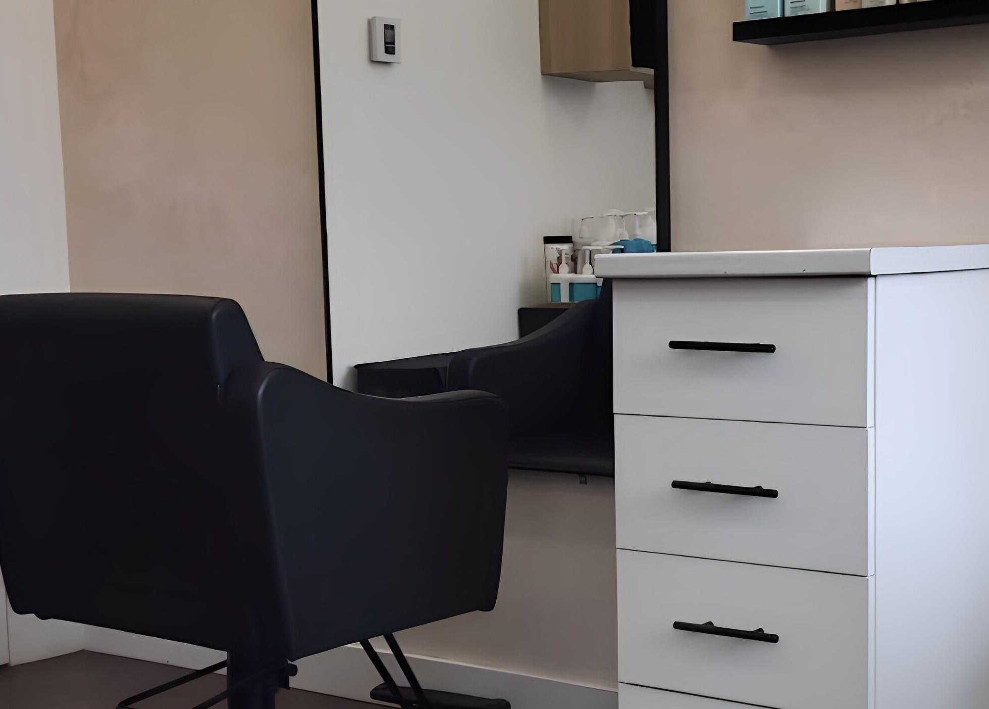 Espace coiffure chic chez Sarah Lespérance à Montréal, Québec, CA, avec fauteuil noir et miroir.