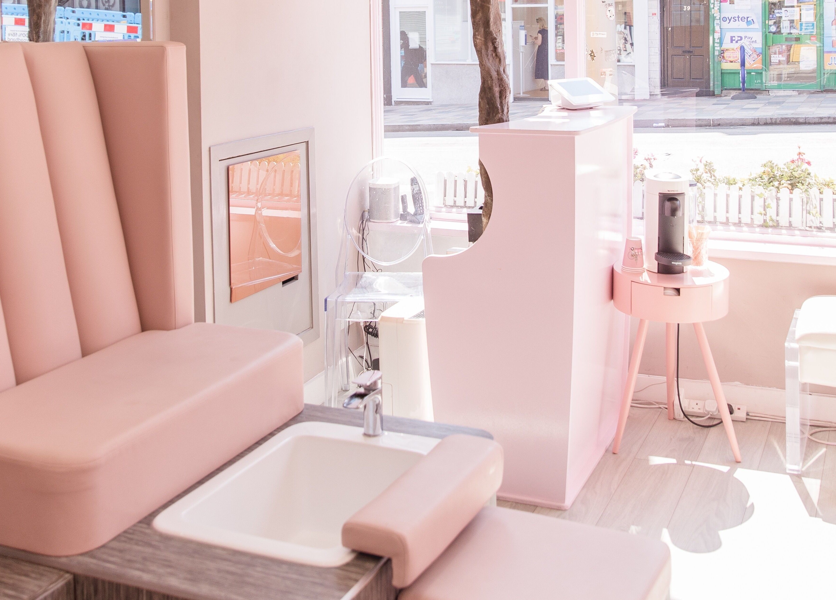 Chic interior of Nail'd It Clapham, London, England, GB with elegant pink seating and a manicure station.
