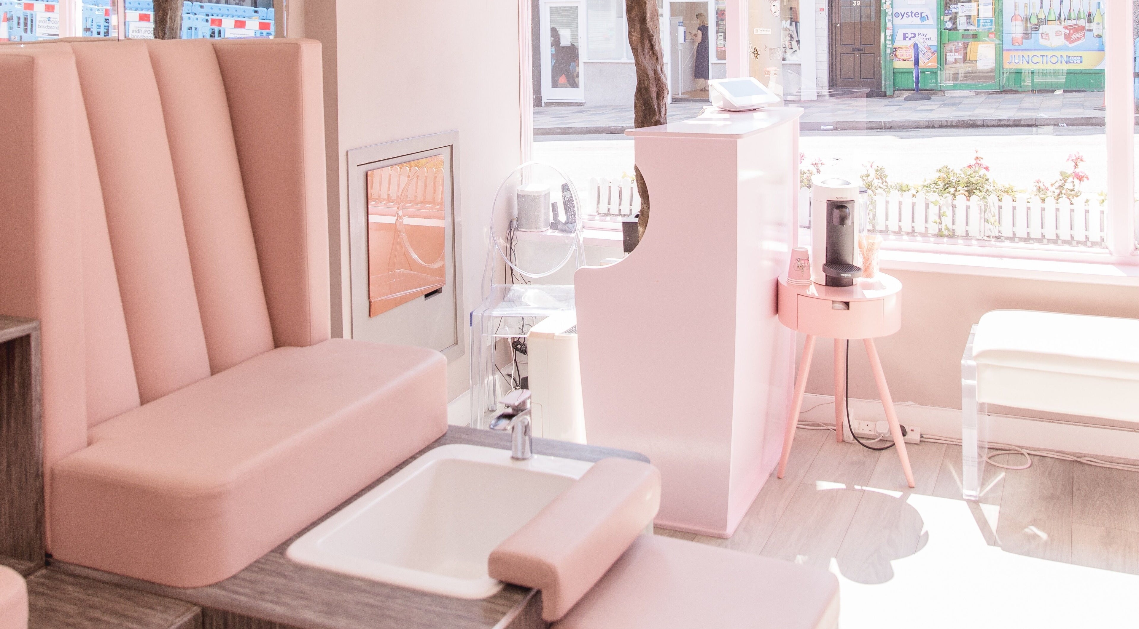 Chic interior of Nail'd It Clapham, London, England, GB with elegant pink seating and a manicure station.