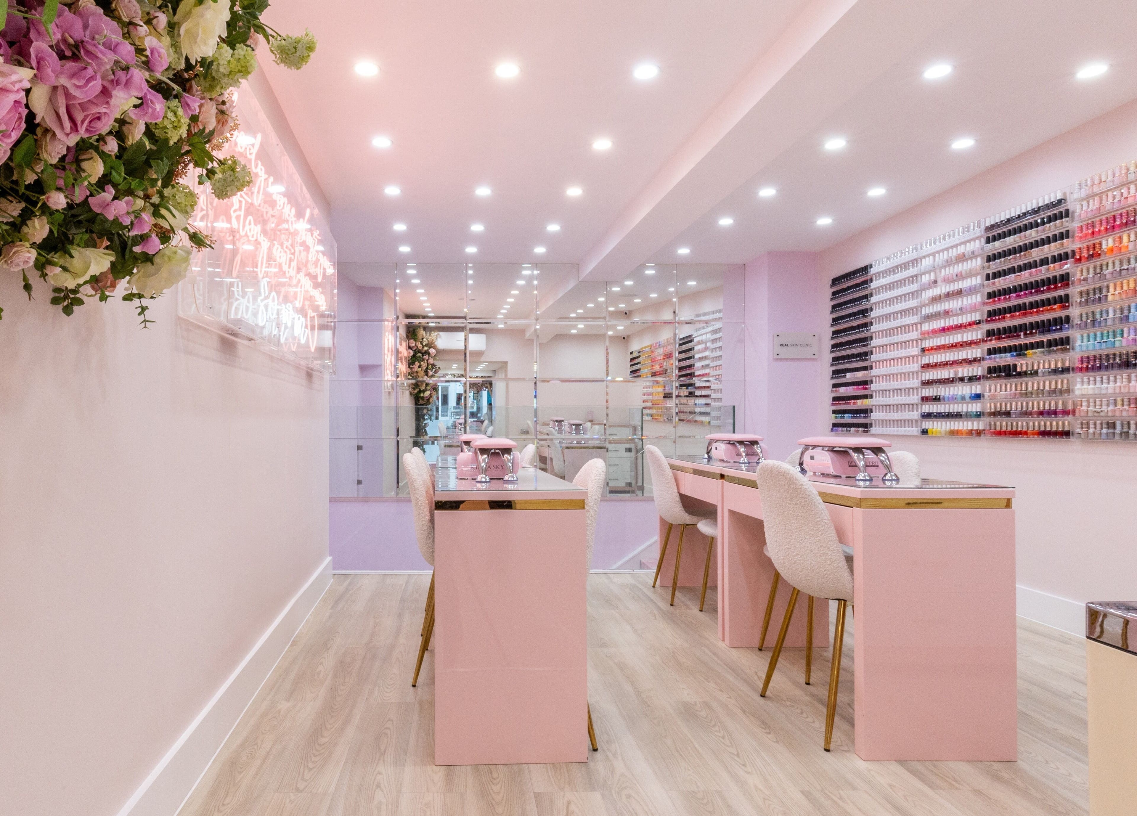 Elegant nail salon interior at Nail'd It Marylebone, London, England, GB with pink decor and polish display.