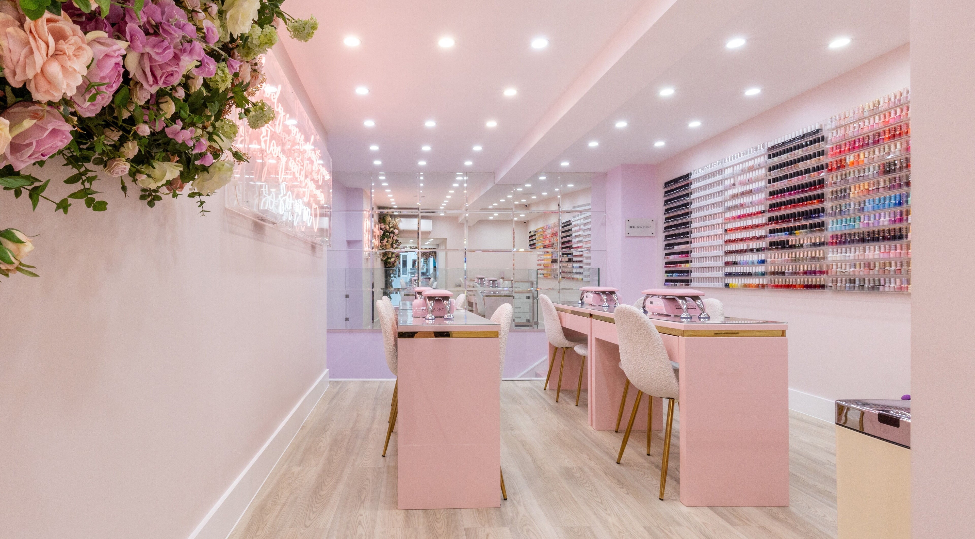 Elegant nail salon interior at Nail'd It Marylebone, London, England, GB with pink decor and polish display.
