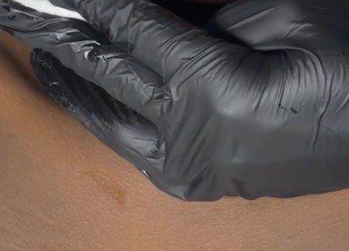 A gloved hand gently cleansing skin at Bella Perfection Salon in Eglinton, Western Australia, AU.