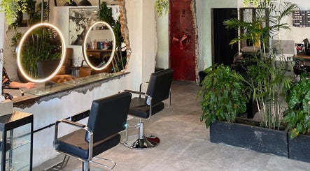 Modern salon at The Gardezan, Bali, Bali, ID, featuring stylish decor, lush plants, and circular mirrors.