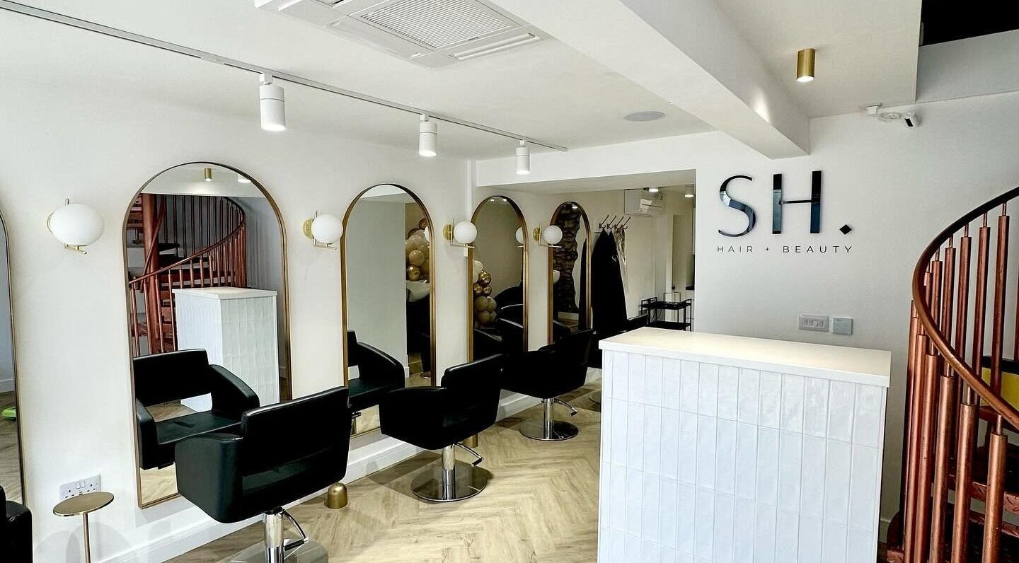 Modern salon interior at SH Hair + Beauty, featuring stylish chairs and mirrors in Bridgend, Wales, GB.