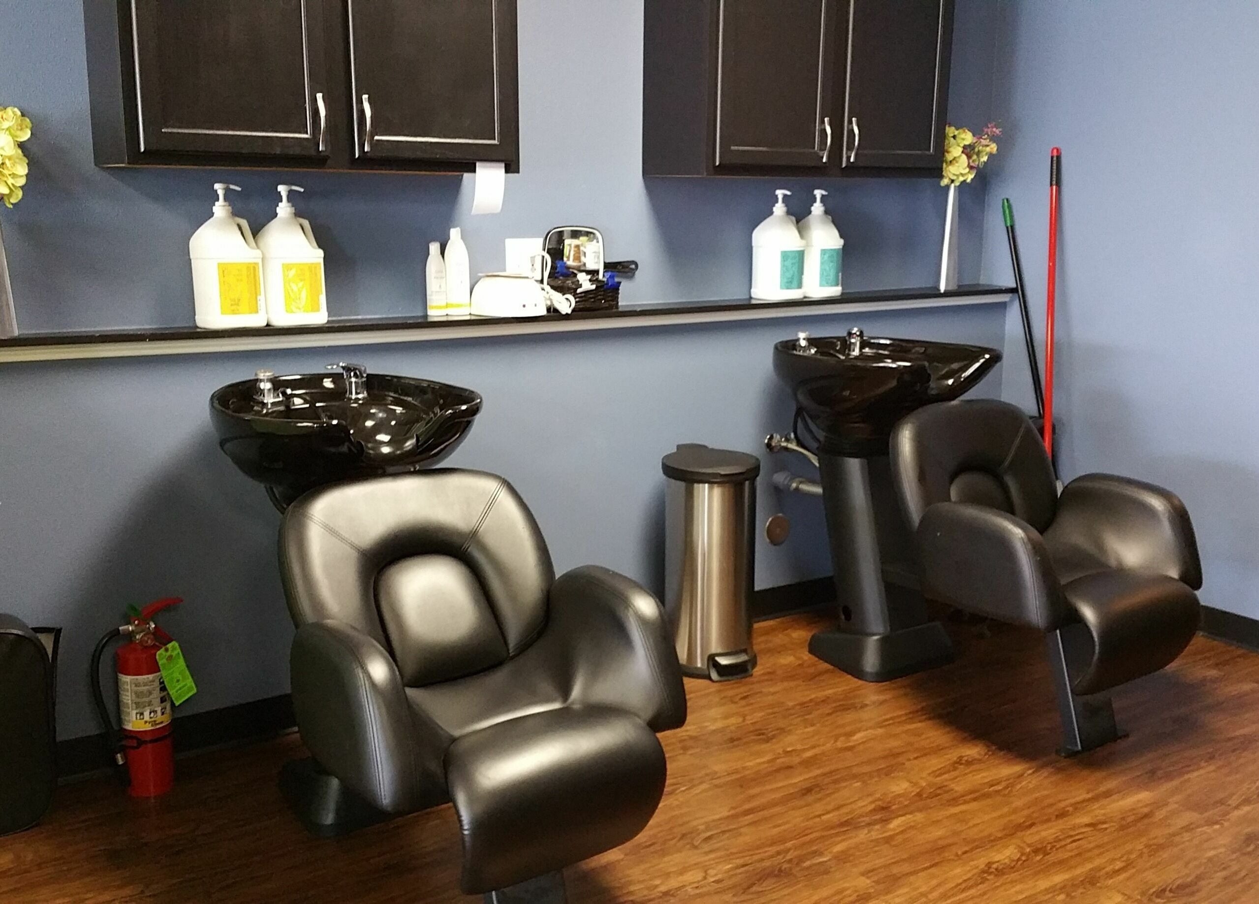 Chic hair wash station at Genesis Salon and Spa in Boscobel, Wisconsin, US, with comfy black chairs and elegant decor.