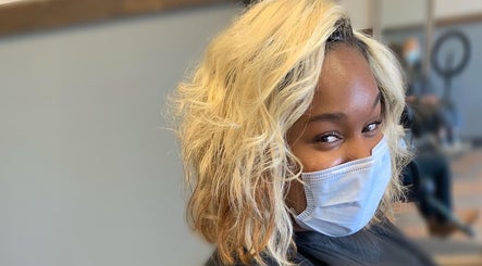 Smiling client in mask at Pressed Unlimited salon, Jacksonville, Florida, US, with stylish blonde hairstyle.
