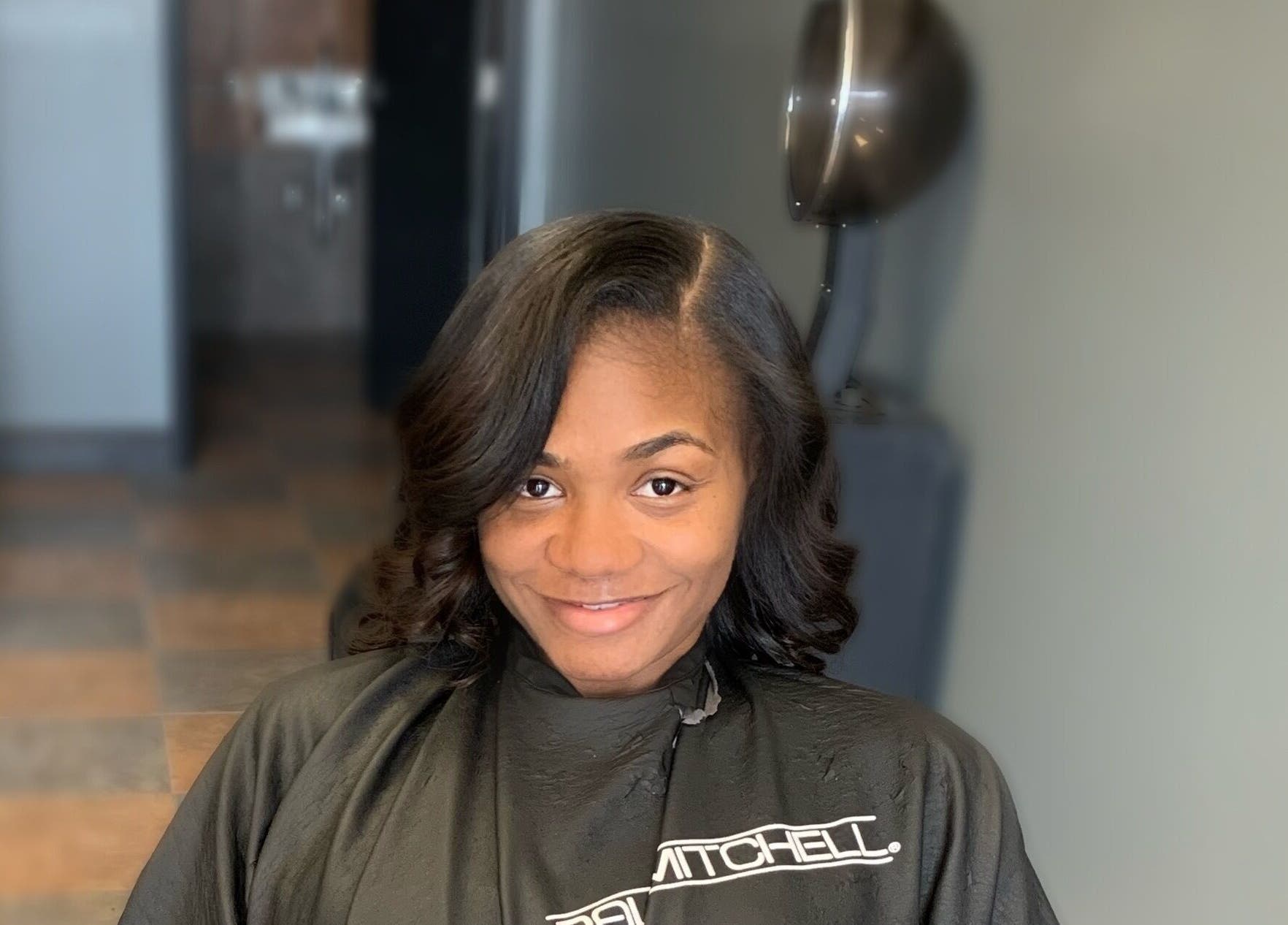 Smiling woman after hair styling at Pressed Unlimited in Jacksonville, Florida, US.