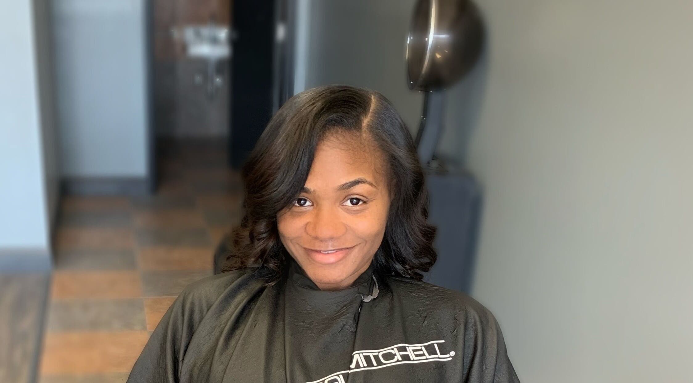 Smiling woman after hair styling at Pressed Unlimited in Jacksonville, Florida, US.