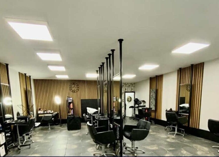 Modern salon interior at ML Studio in Pontefract, England with sleek black chairs and styled mirrors.