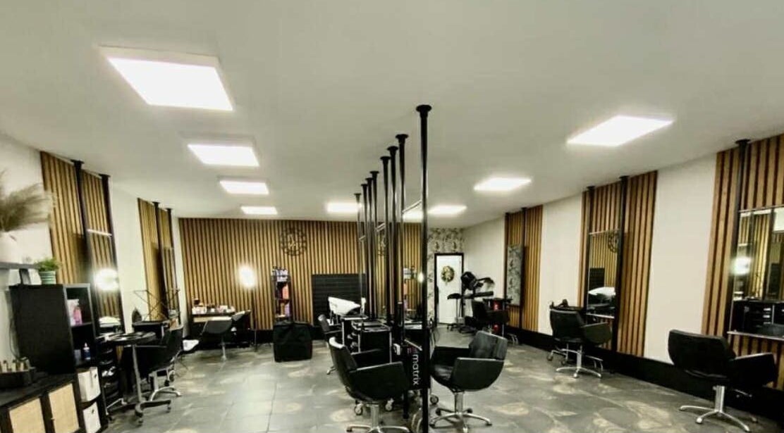 Modern salon interior at ML Studio in Pontefract, England with sleek black chairs and styled mirrors.