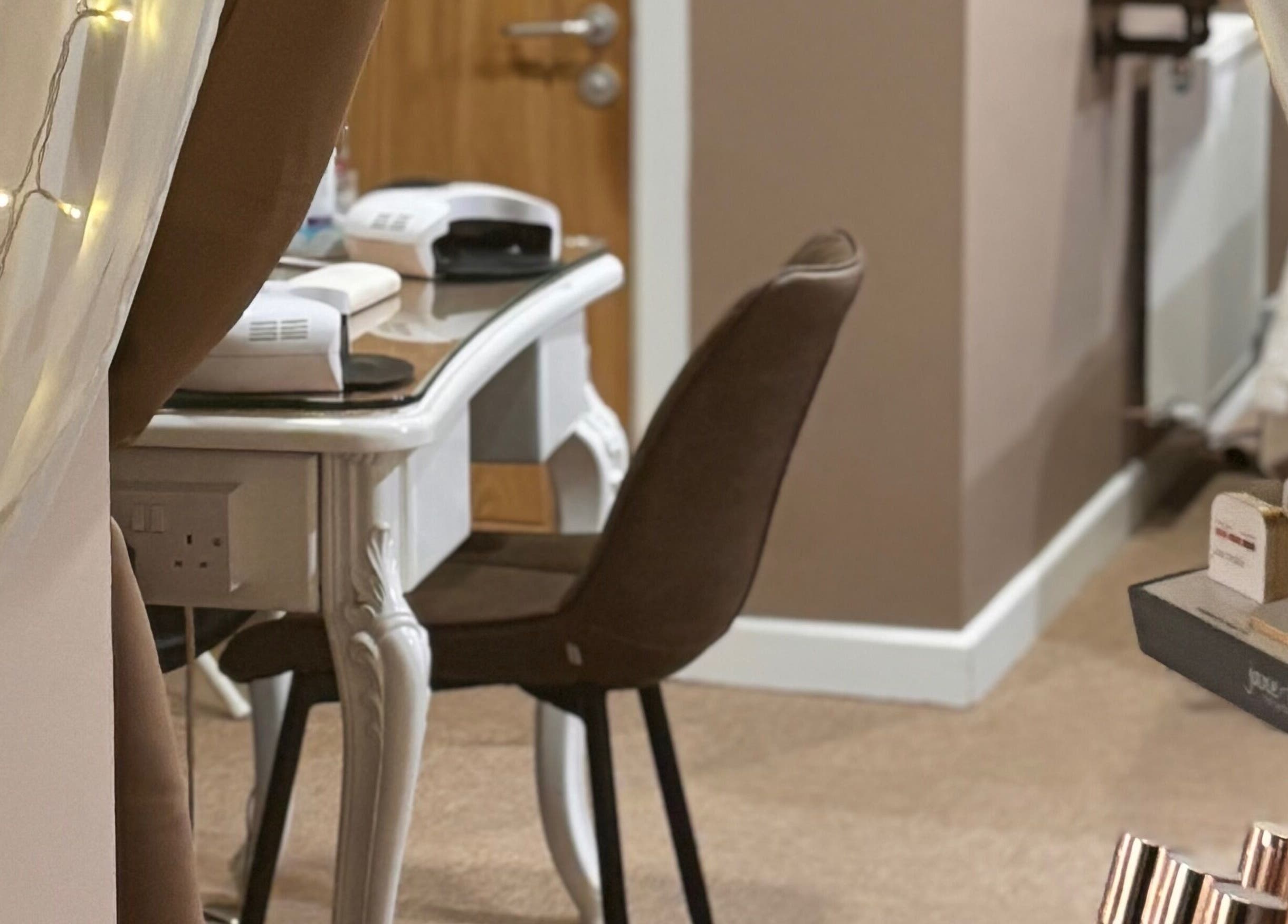 Elegance Beauty in Osmaston, England, GB features a cozy beauty setup with a stylish chair and table.
