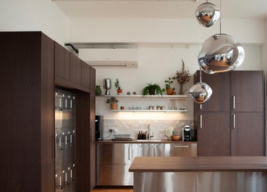 Modern kitchen at Studio 90, London, England, GB with sleek wood cabinets and stainless steel appliances.