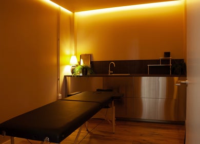 Cozy massage room at Studio 90, London, England, GB with soft lighting and a massage table.