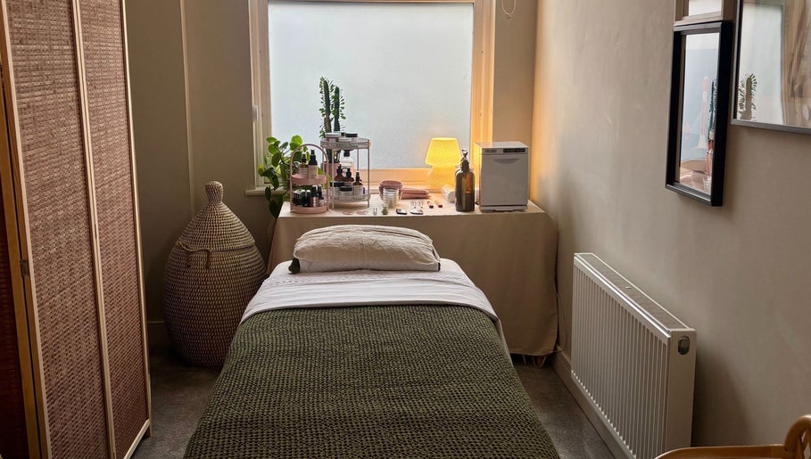 Tranquil therapy room at Aceso Healing Therapies, Margate, England, GB, featuring a bed and skincare products.