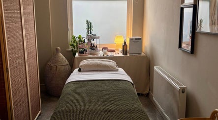 Tranquil therapy room at Aceso Healing Therapies, Margate, England, GB, featuring a bed and skincare products.
