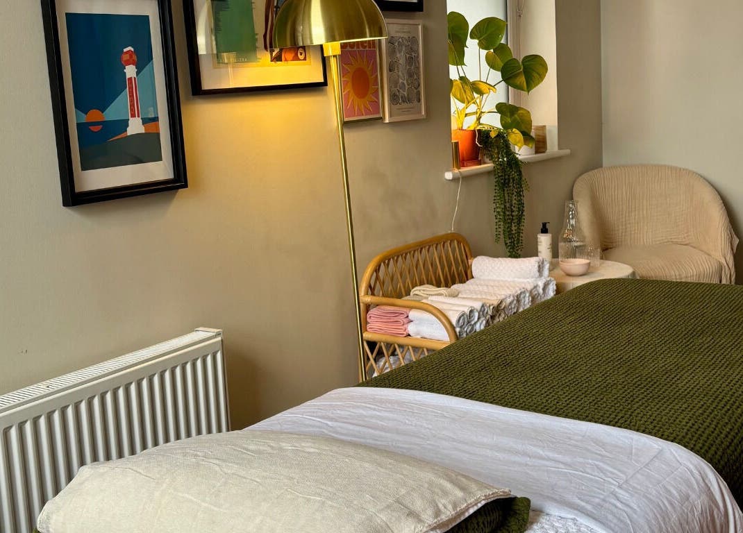 Cozy treatment room at Aceso Healing Therapies, Margate, England, GB with plush bedding, art, and decor.
