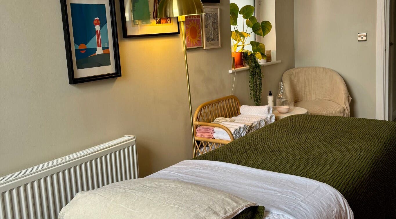 Cozy treatment room at Aceso Healing Therapies, Margate, England, GB with plush bedding, art, and decor.