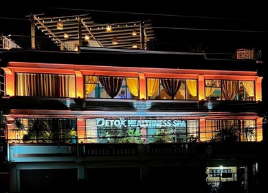 Illuminated facade of Detox Wellness in San Fernando, Ilocos Region, PH, glowing warmly in the night.