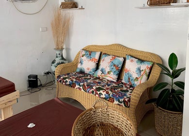 Relaxing lounge area at Detox Wellness, San Fernando, Ilocos Region, PH with floral cushions and natural decor.