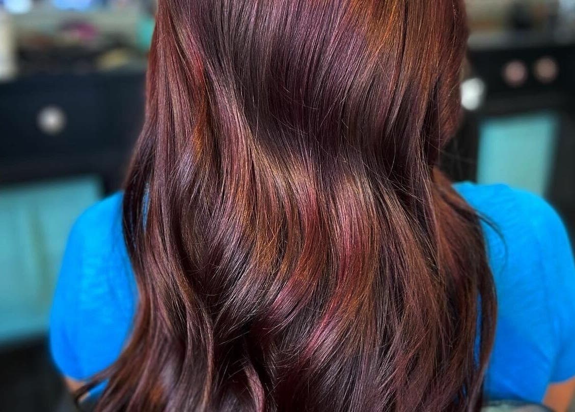 Close-up of vibrant reddish hair styled at Aaries Styles Salon in Ypsilanti, Michigan, US.