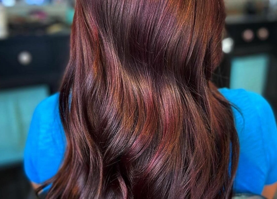 Close-up of vibrant reddish hair styled at Aaries Styles Salon in Ypsilanti, Michigan, US.