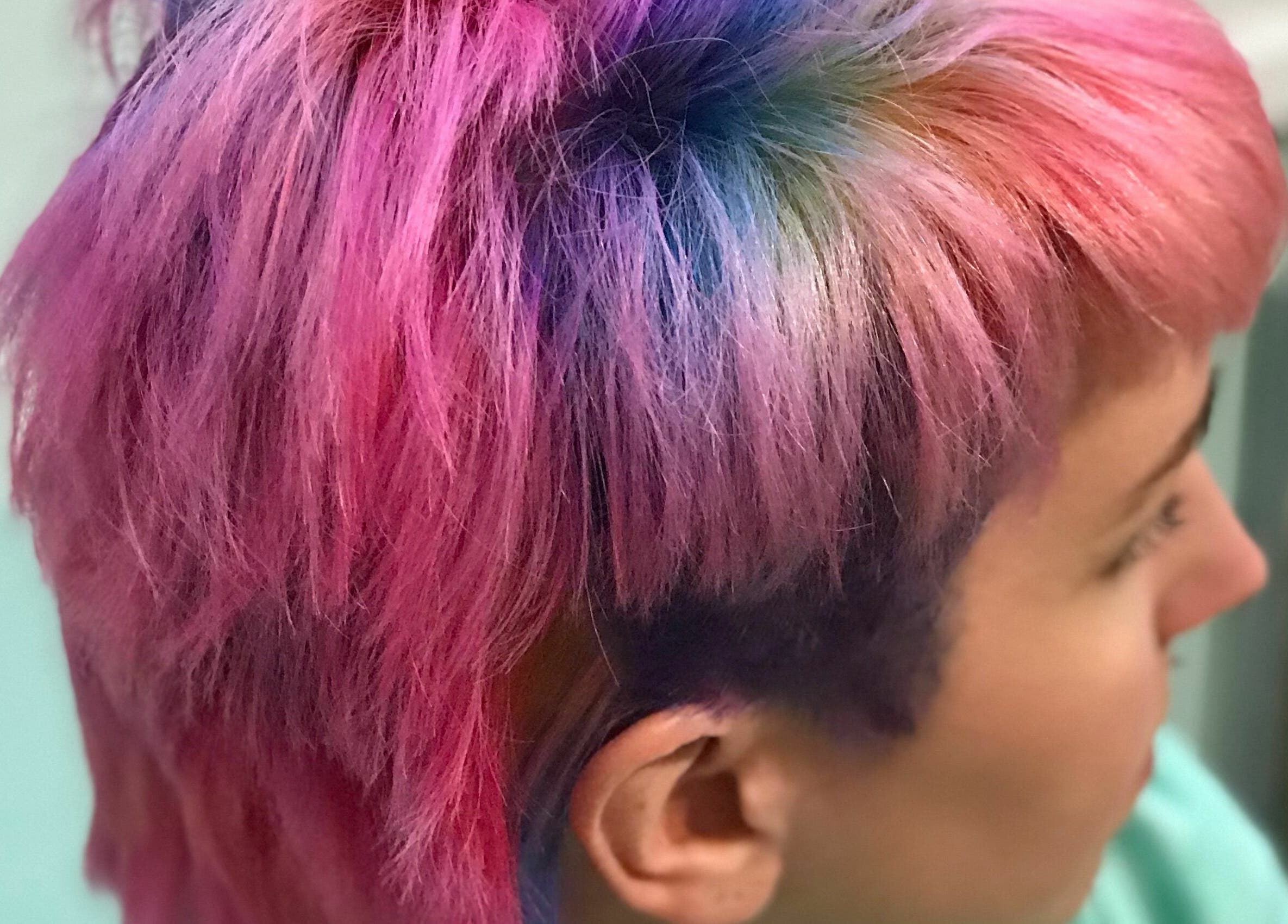 Colorful short hairstyle at Aaries Styles Salon in Ypsilanti, Michigan, US showcasing vibrant pink tones.
