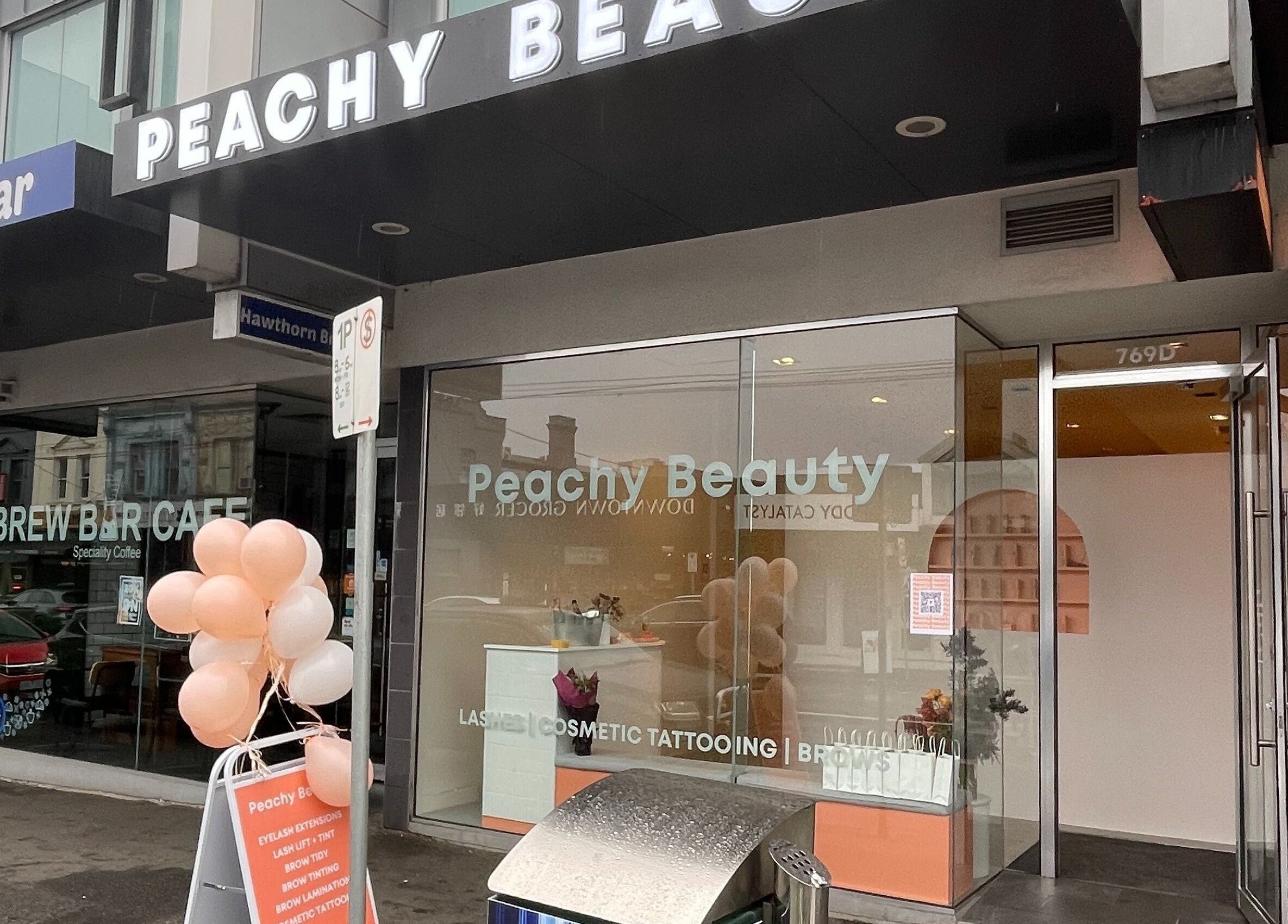 Exterior of Peachy Beauty in Hawthorn, Victoria, AU with sign and decor.