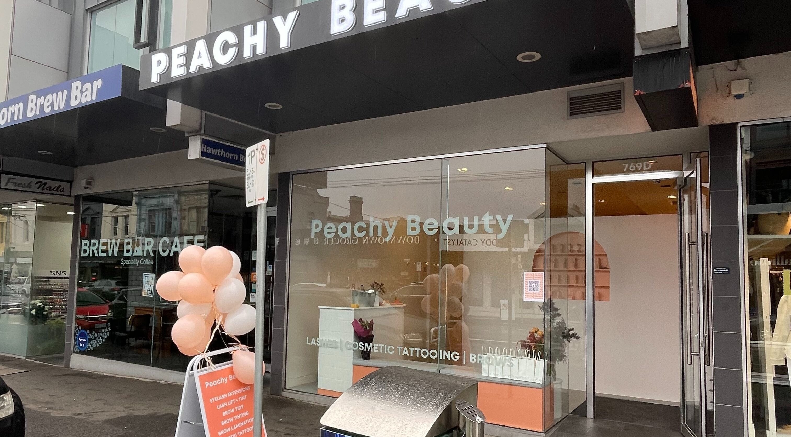Exterior of Peachy Beauty in Hawthorn, Victoria, AU with sign and decor.