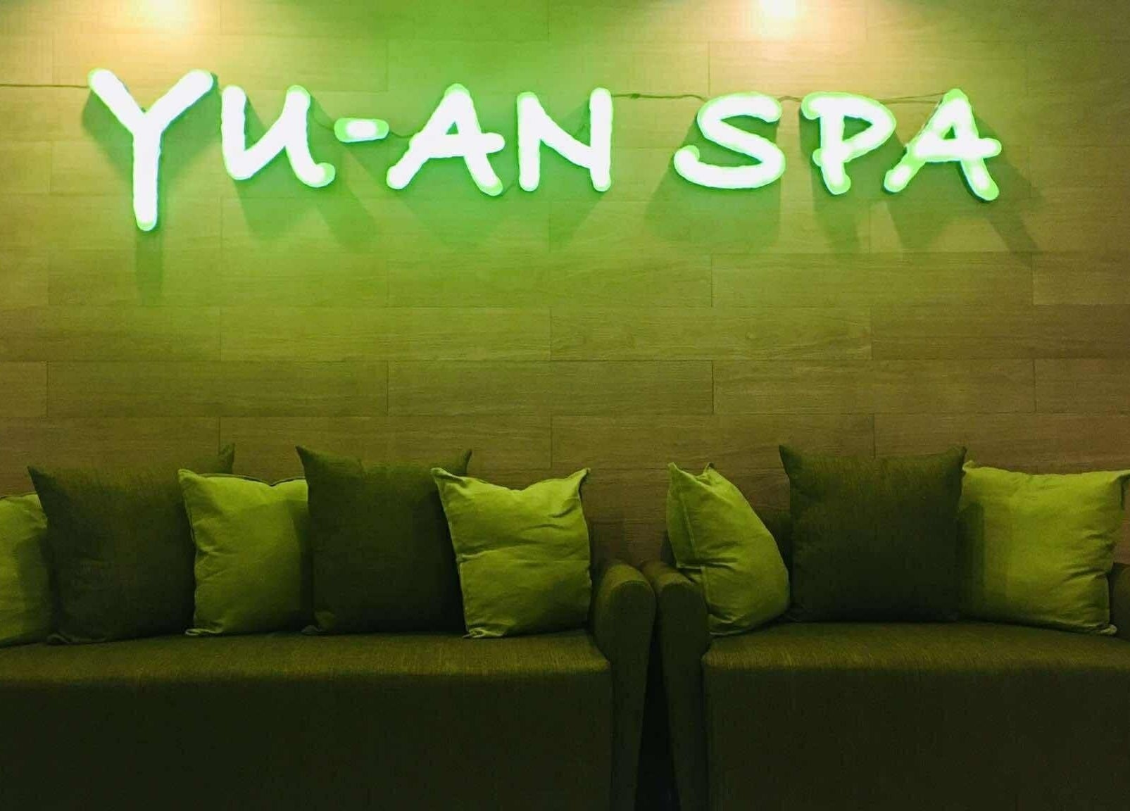 Cozy seating area at Yuan Spa, City of Balanga, Central Luzon, PH, with green neon sign.