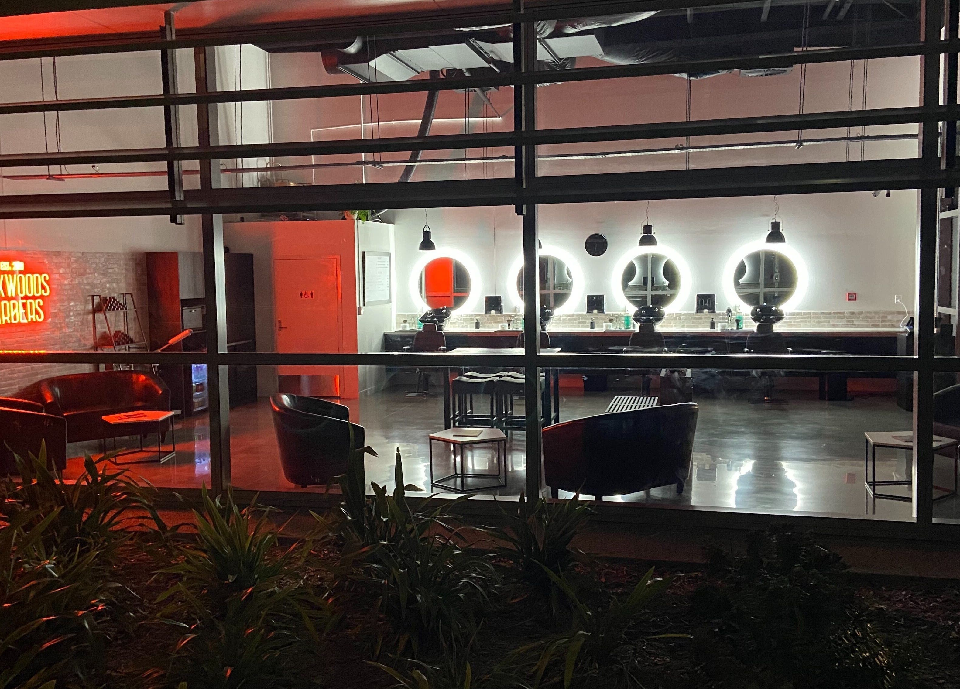 Interior view of Kirkwoods Barbers Stoneridge in Auckland, NZ with stylish lighting and modern decor.