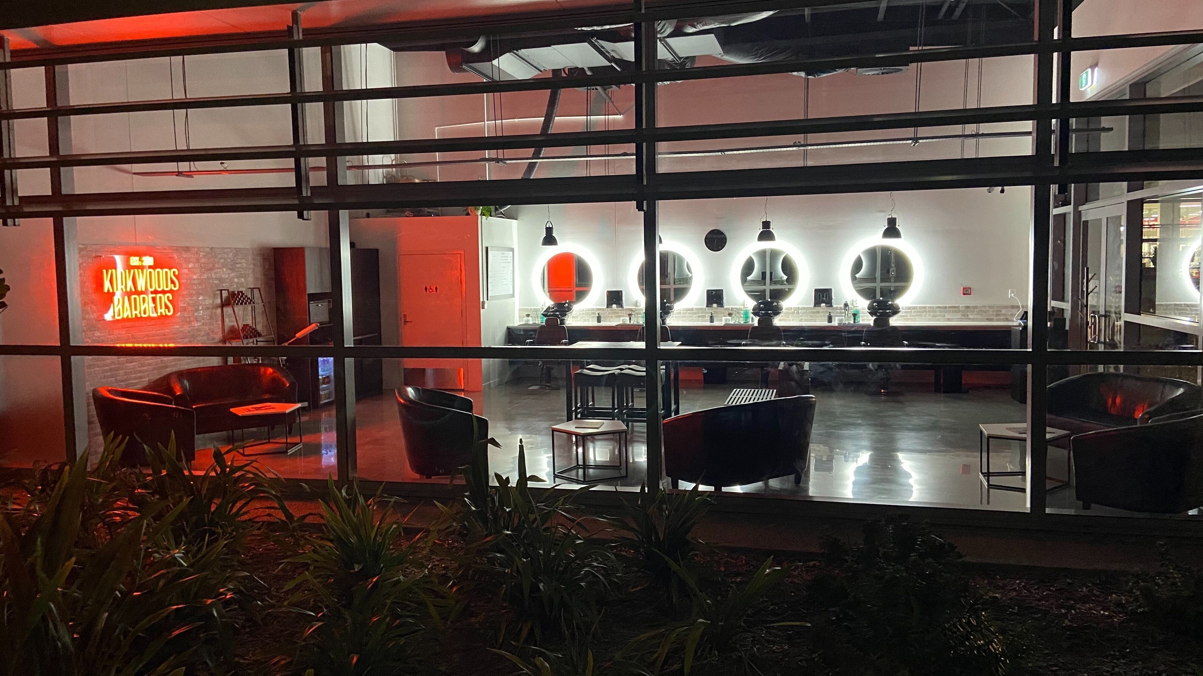 Interior view of Kirkwoods Barbers Stoneridge in Auckland, NZ with stylish lighting and modern decor.