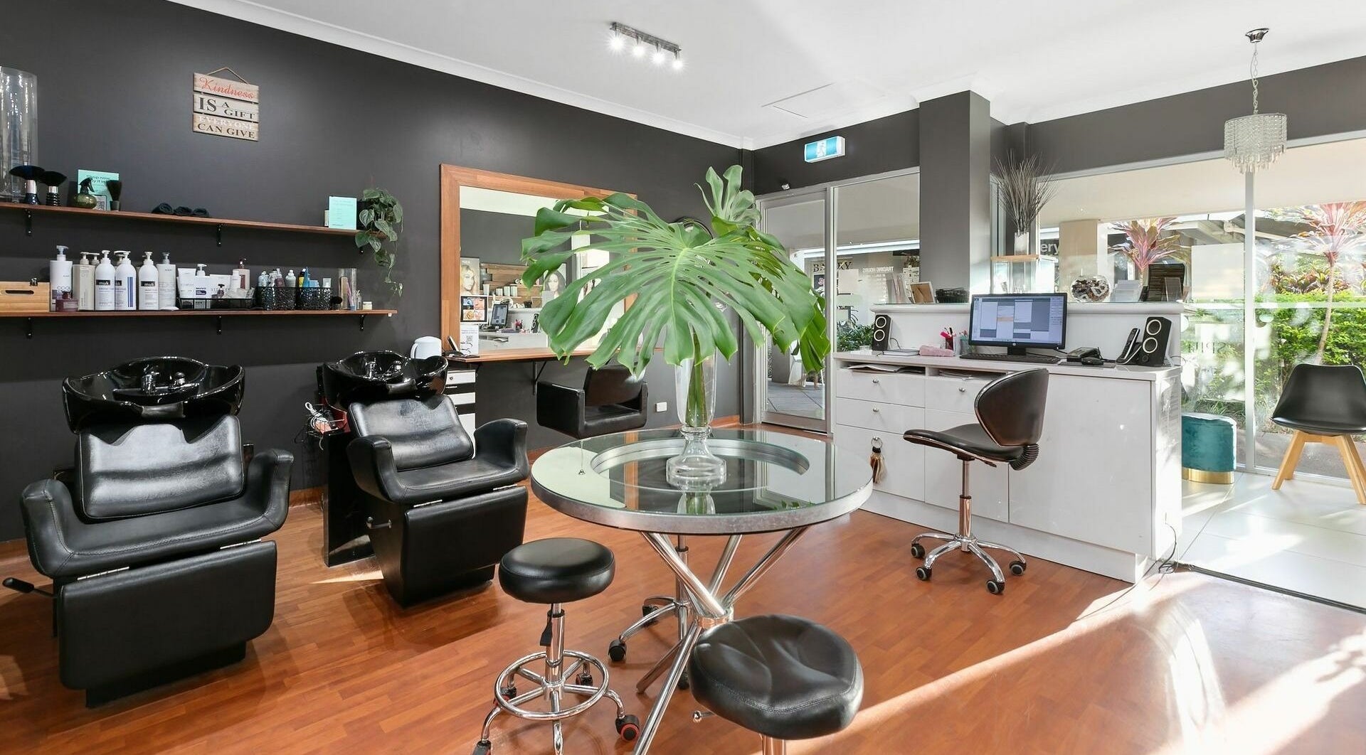 Elegant salon interior at Noosaville Hair & Beauty, Noosaville, Queensland, AU with stylish black chairs.