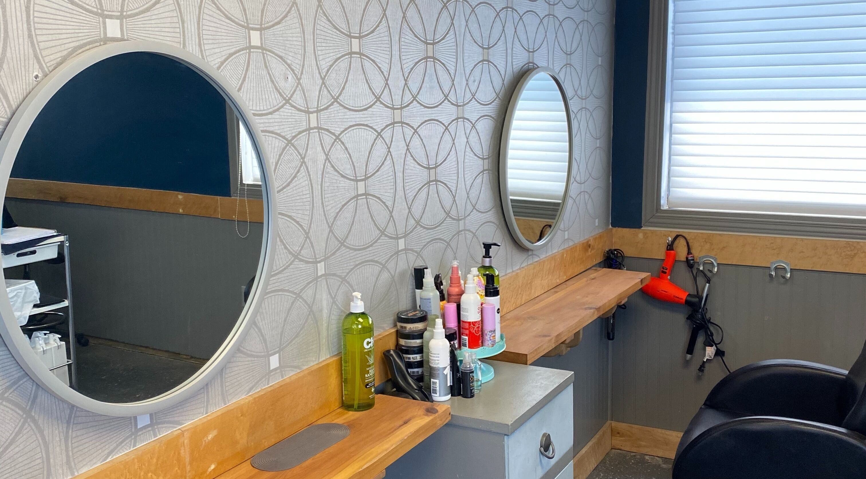 Styling station at Gatehouse Salon in Sault Ste Marie, Ontario, CA with mirrors and hair products.