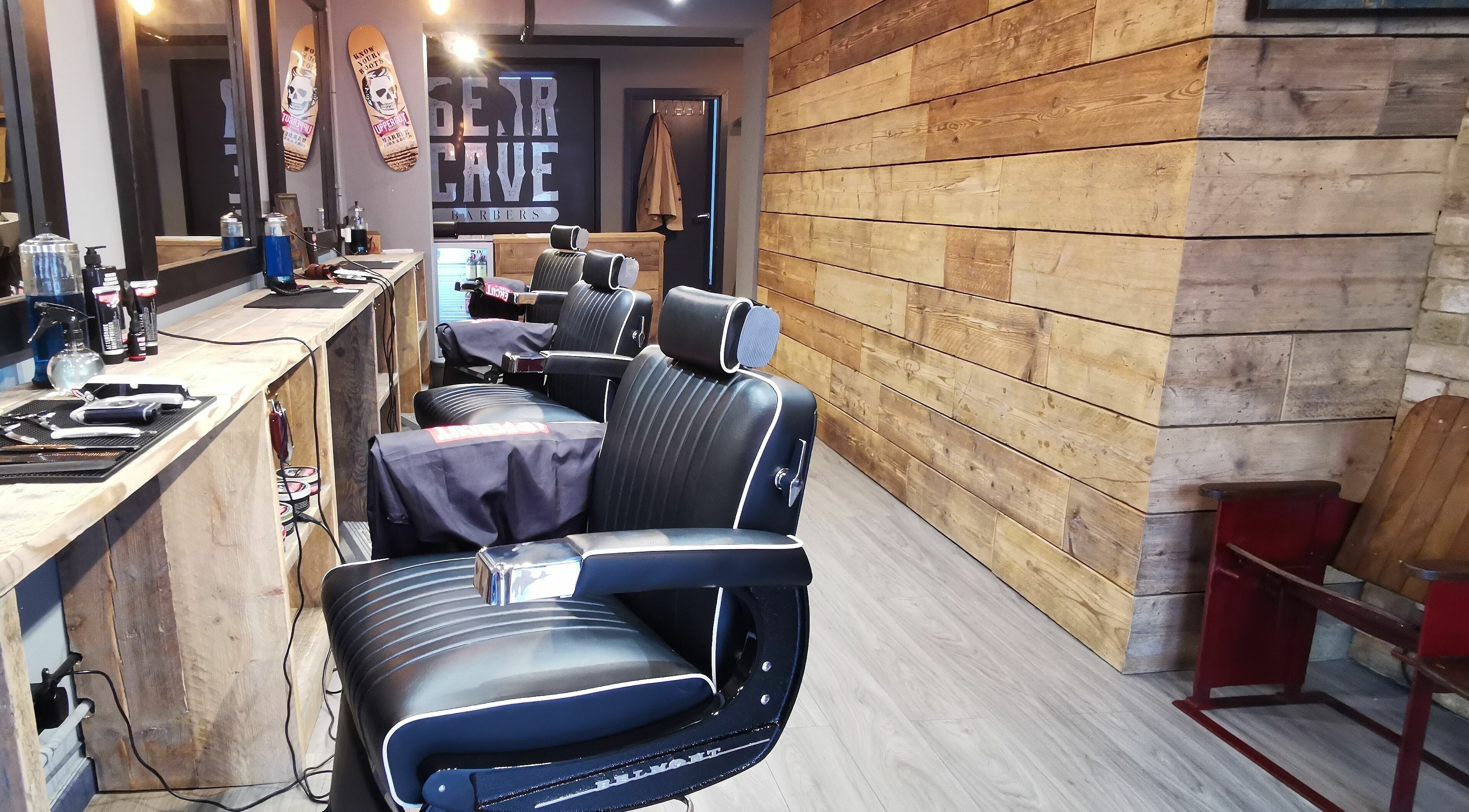 Interior view of Bear Cave Barbers in London, England, GB with stylish chairs and rustic wood decor.