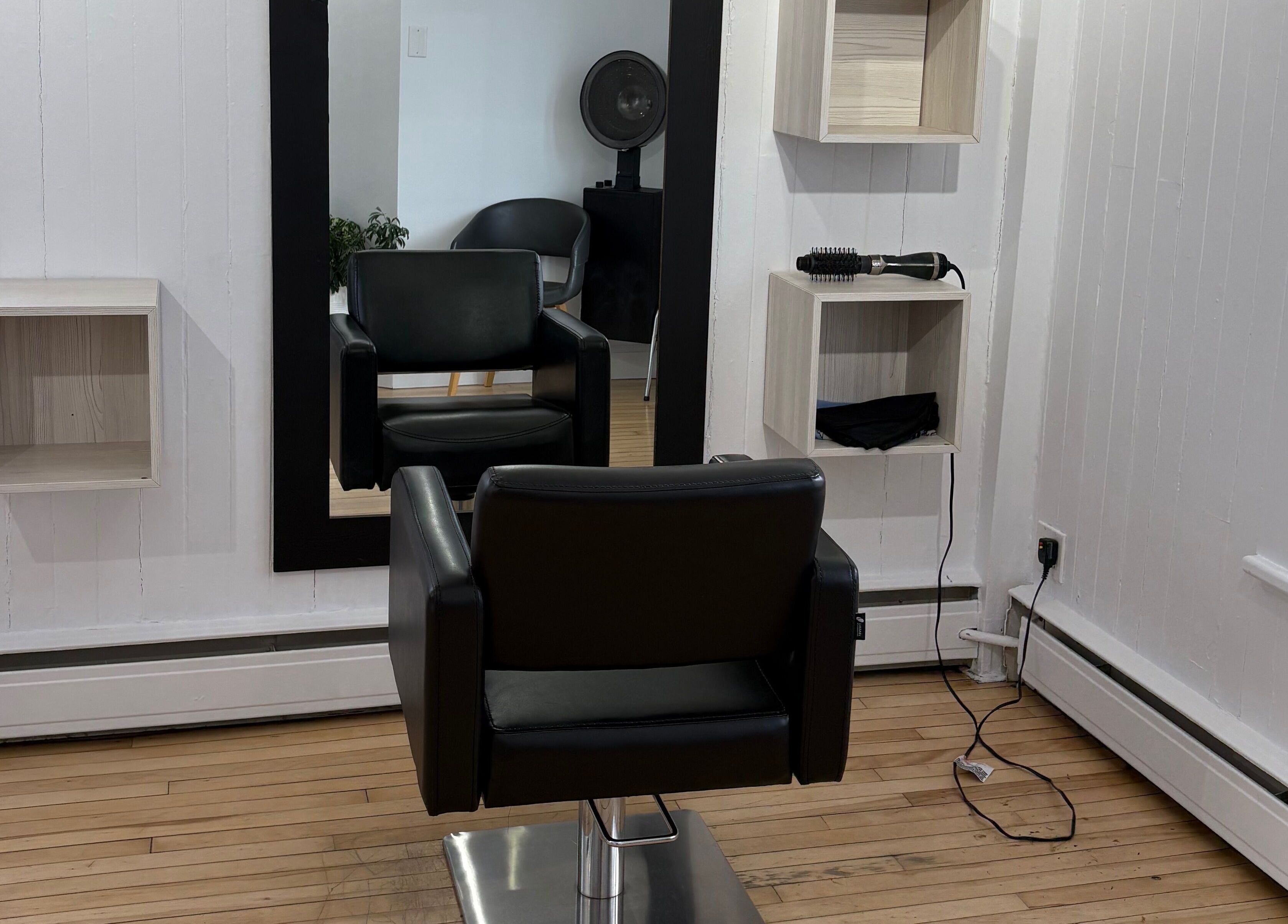 Interieur de Atelier Coiffure 212 (Kathleen) à Rimouski, Québec, CA, présentant un fauteuil moderne.