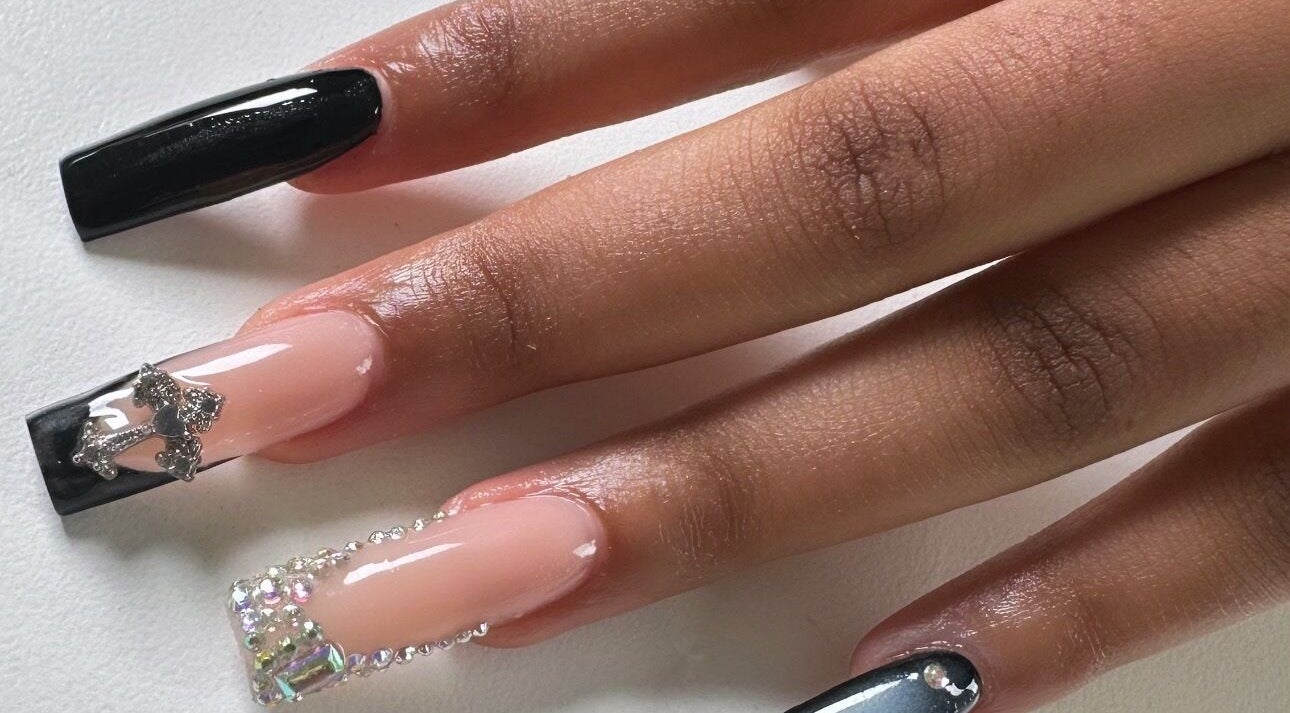 Elegant nail art at Shinnel Beauty in Johannesburg, Gauteng, ZA features glossy black and nude shades with rhinestones.