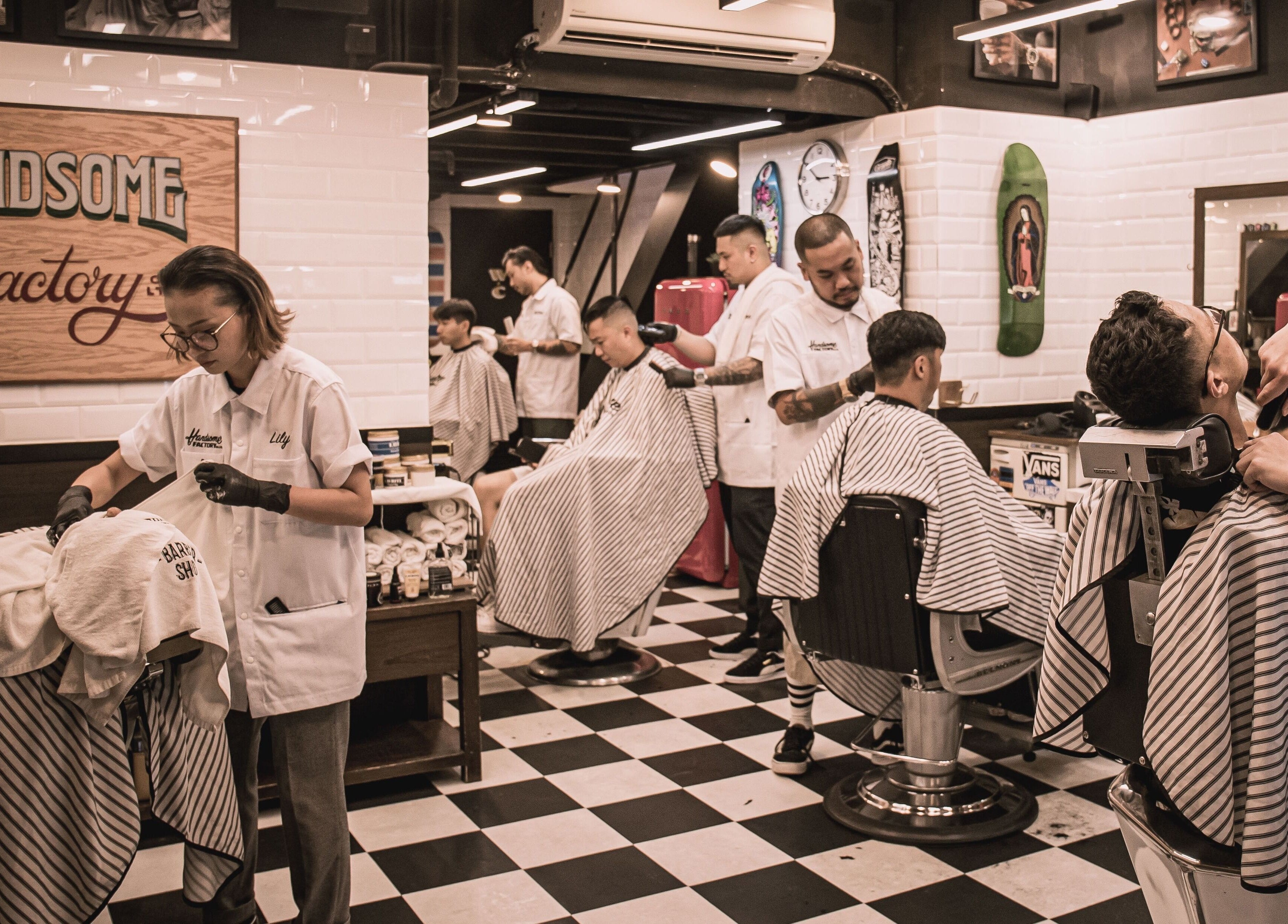 Stylish interior of Tsim Sha Tsui | Handsome Factory Barber Shop in Kowloon, Kowloon, HK with customers and barbers.