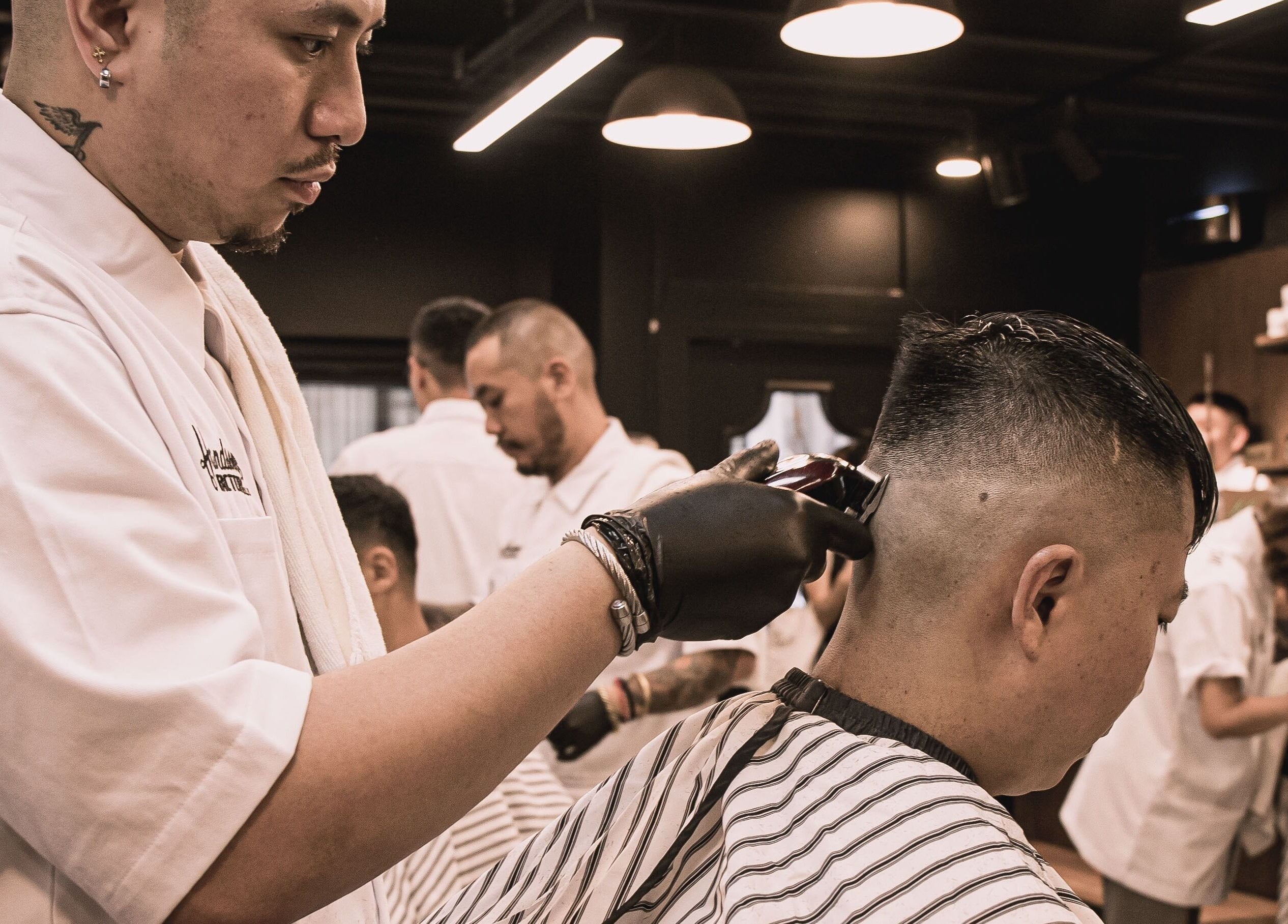 Expert barber at Tsim Sha Tsui | Handsome Factory Barber Shop in Kowloon, HK, performing a precise haircut.