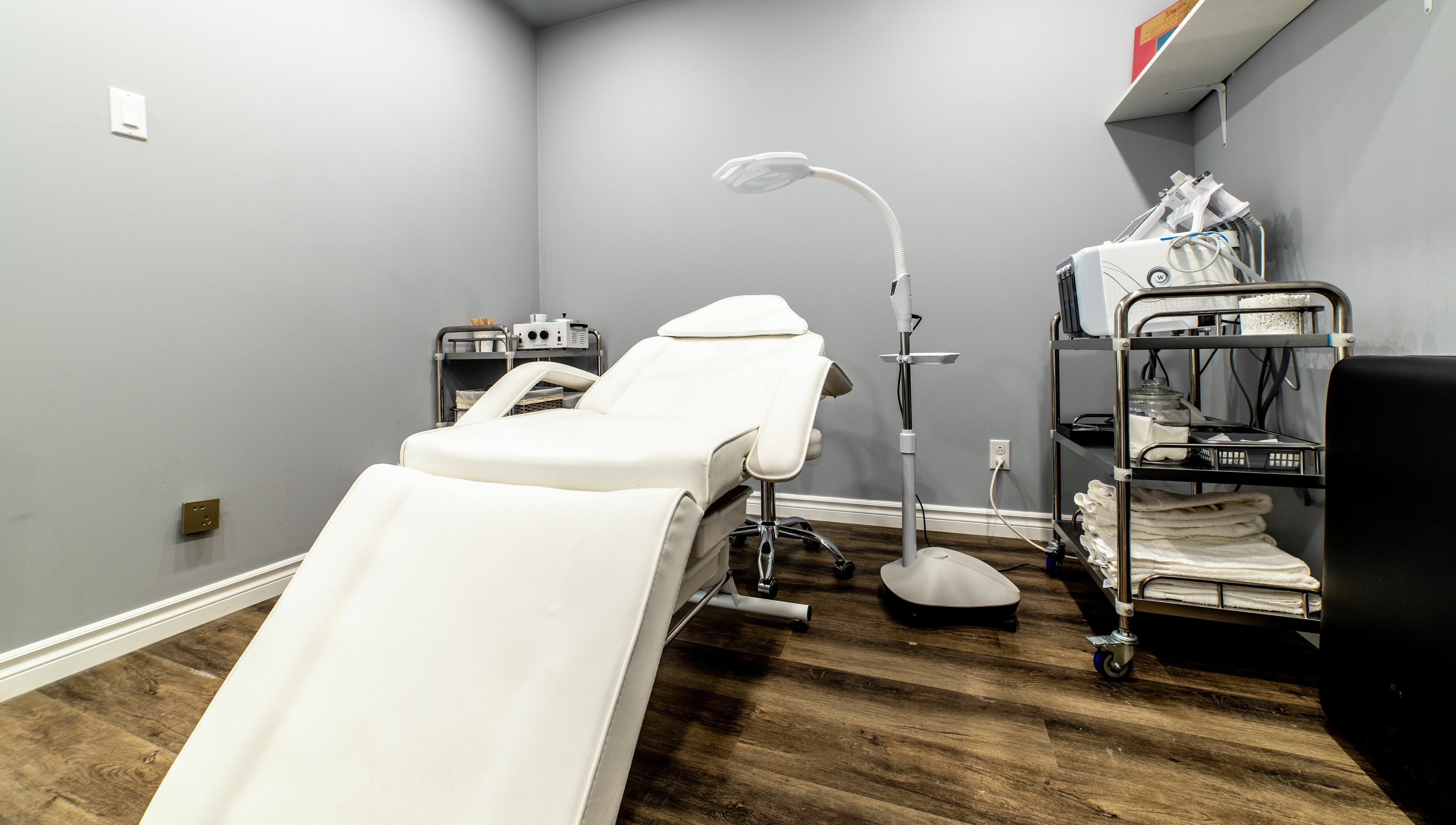 Elegant treatment room at Uni Esthetique featuring a comfortable chair and equipment in Montréal, Québec, CA.
