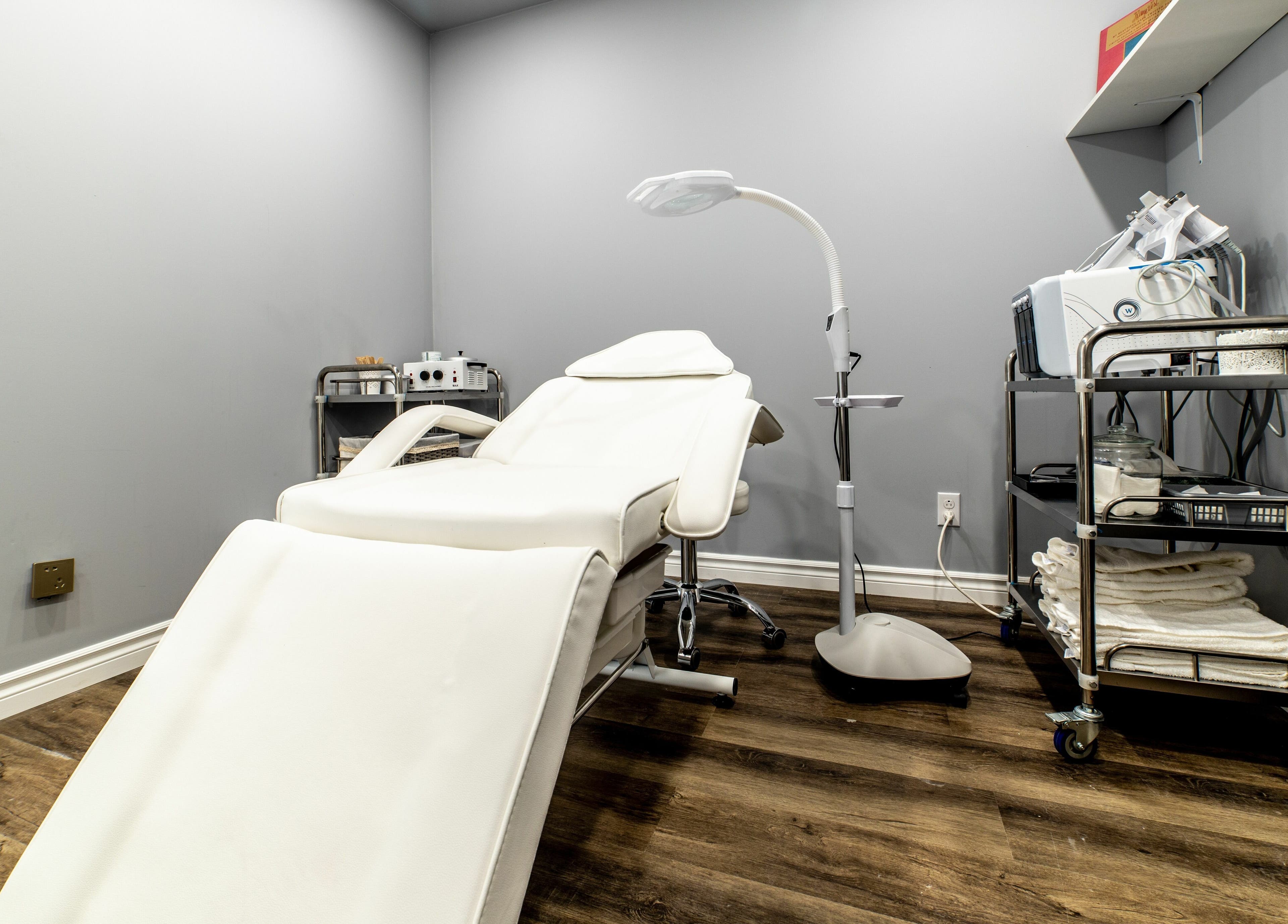 Elegant treatment room at Uni Esthetique featuring a comfortable chair and equipment in Montréal, Québec, CA.