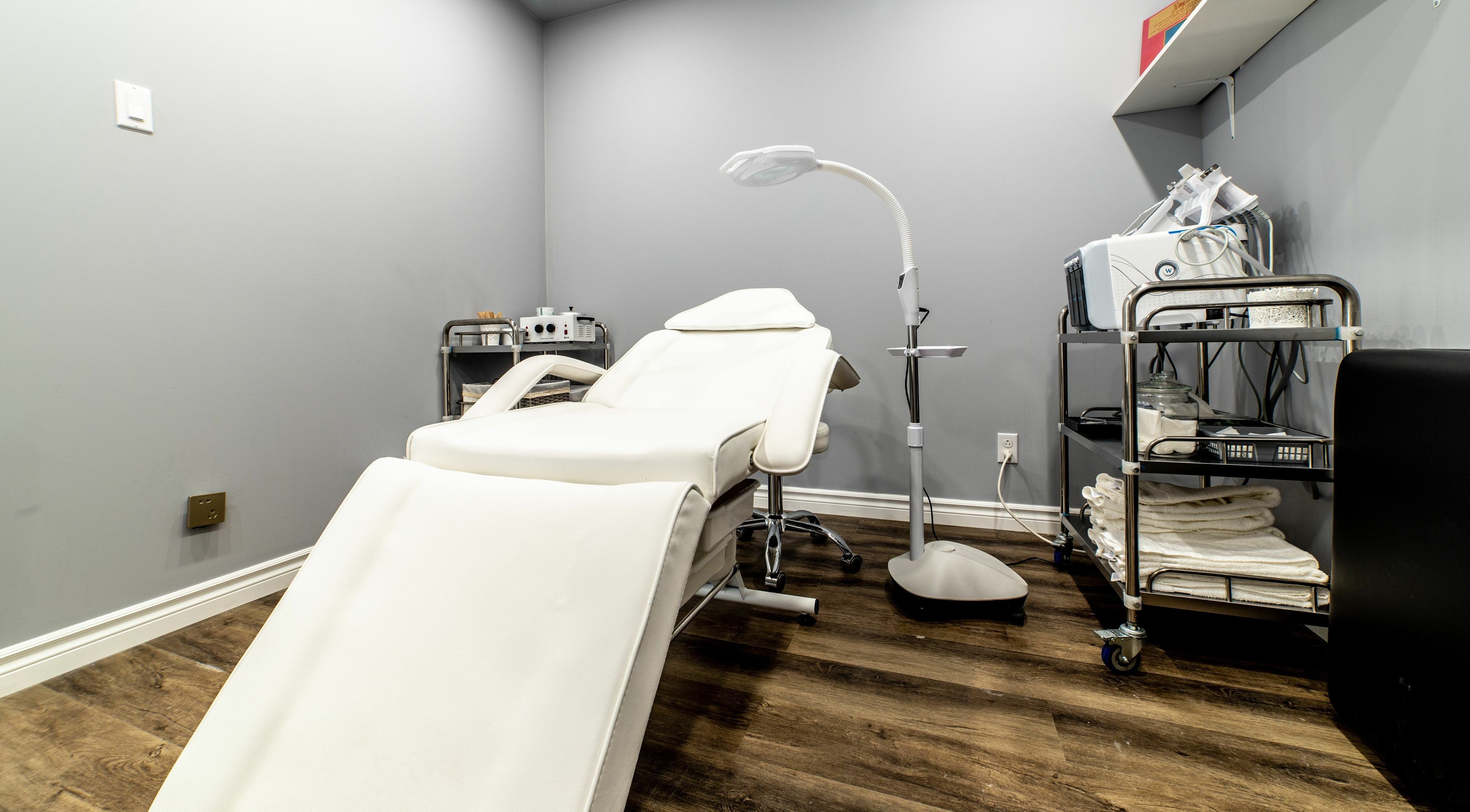 Elegant treatment room at Uni Esthetique featuring a comfortable chair and equipment in Montréal, Québec, CA.